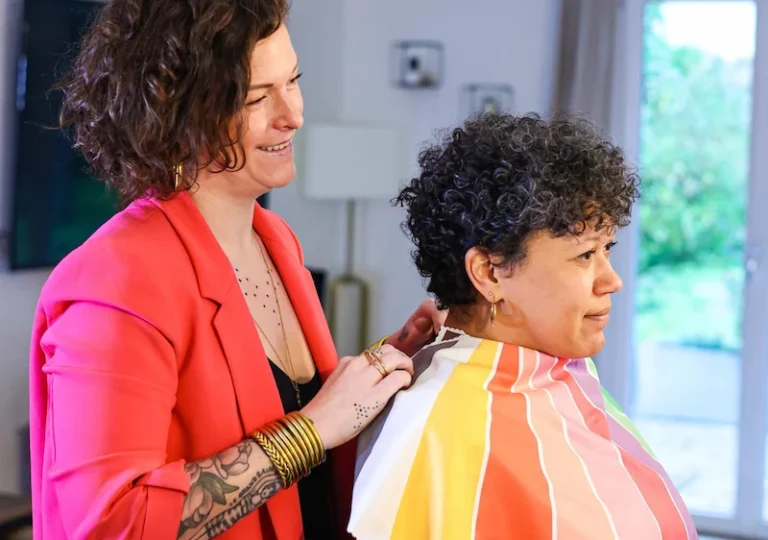 Coiffeuse coupant cheveux courts bouclés en salon
