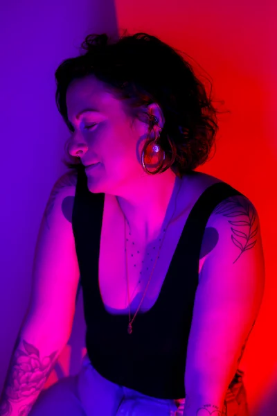 Portrait femme tatouée éclairage rose et rouge