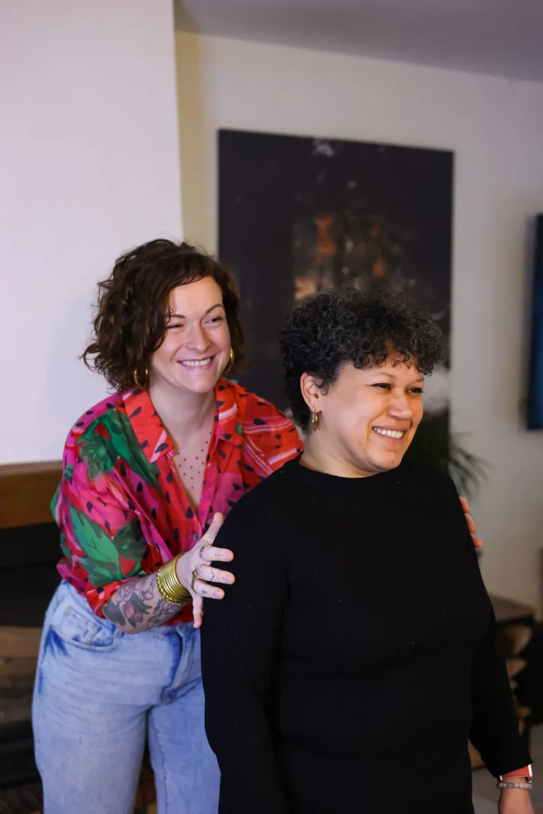 Deux femmes souriantes enlacées en intérieur